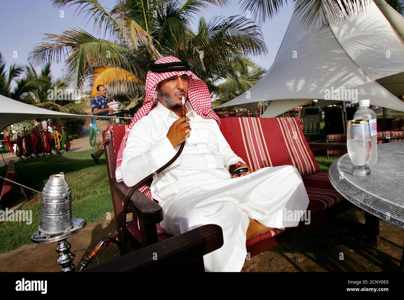 A Saudi man smokes a water pipe as he sits on a beach in Jeddah city in Saudi Arabia April 14, 2005. REUTERS/Ahmed Jadallah  AJ/VP Stock Photo