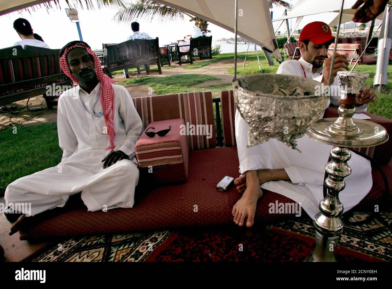 Saudi men smoke water pipe as they sit on a beach in Jeddah city in Saudi Arabia April 14, 2005. REUTERS/Ahmed Jadallah  AJ/TZ Stock Photo