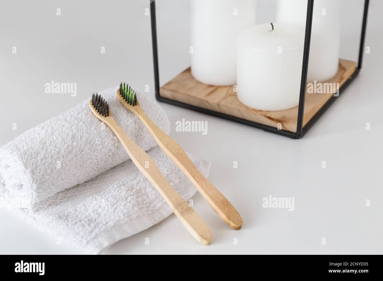Ceramic cup with wooden toothbrushes on white with copy space