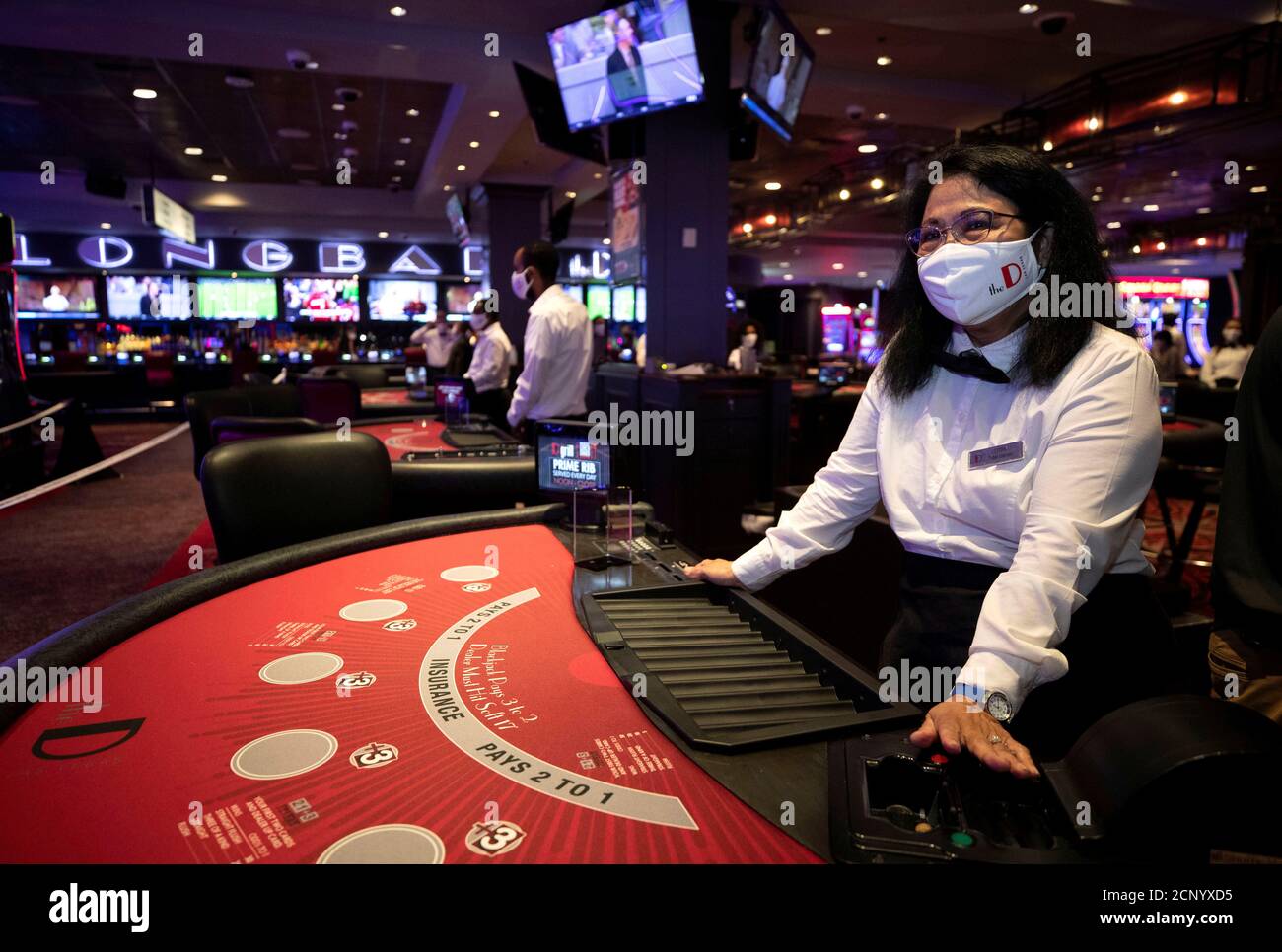 Blackjack dealer Lydia Clark waits by a table as workers prepare for the  June 4 reopening of The D hotel-casino, closed by the state since March 18,  2020 as part of steps