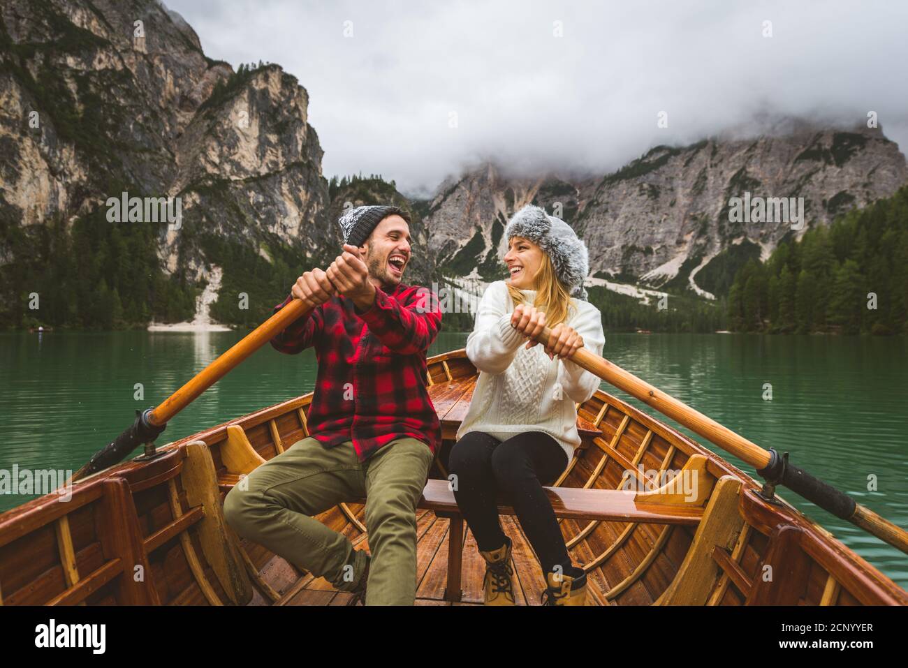 Beautiful Couple Of Young Adults Visiting An Alpine Lake At Braies Italy Tourists With Hiking Outfit Having Fun On Vacation During Autumn Foliage Stock Photo Alamy