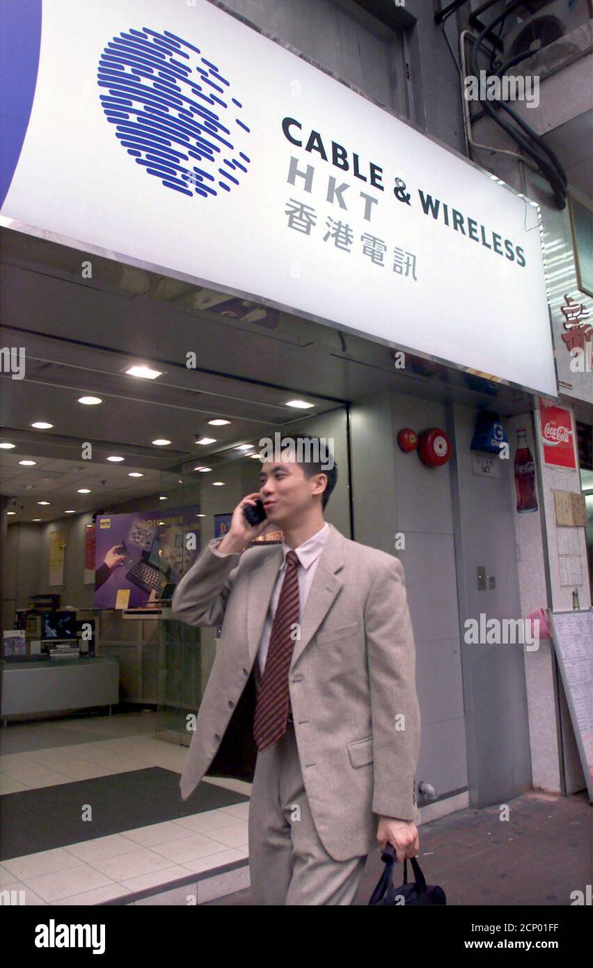 A Man Talking On A Mobile Phone Walks Past A Cable Wireless Hkt Service Center In Hong Kong February 28 Pacific Century Cyberworks Ltd Appeared To Be Closing In On A