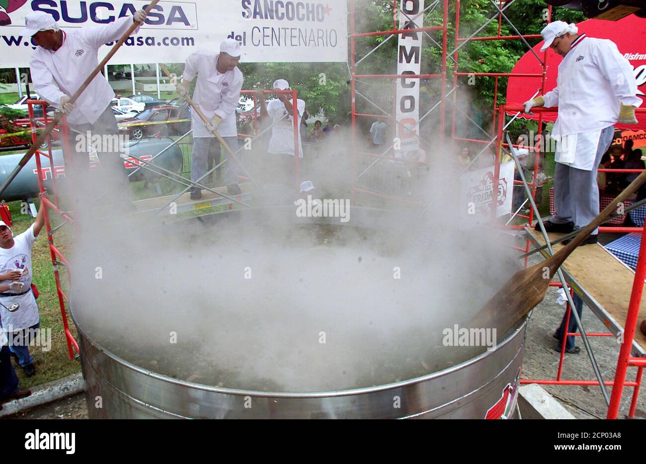 A group of Panamanian chefs mix soup (Sancocho) cooking in a giant saucepan in Panama City, August 16, 2003. Two-thousand-five-hundred-sixty-four gallons of soup were cooked today in attempt to break the Guiness Book of World Records for cooking the largest amount of soup at one time. REUTERS/Alberto Lowe AL/SV Stock Photo