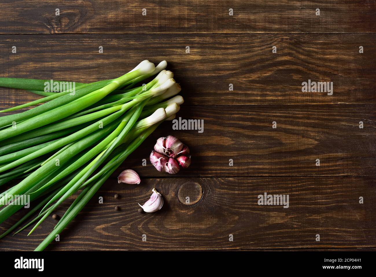 Fresh green onion and garlic on wooden background with free text space. Top view, flat lay Stock Photo