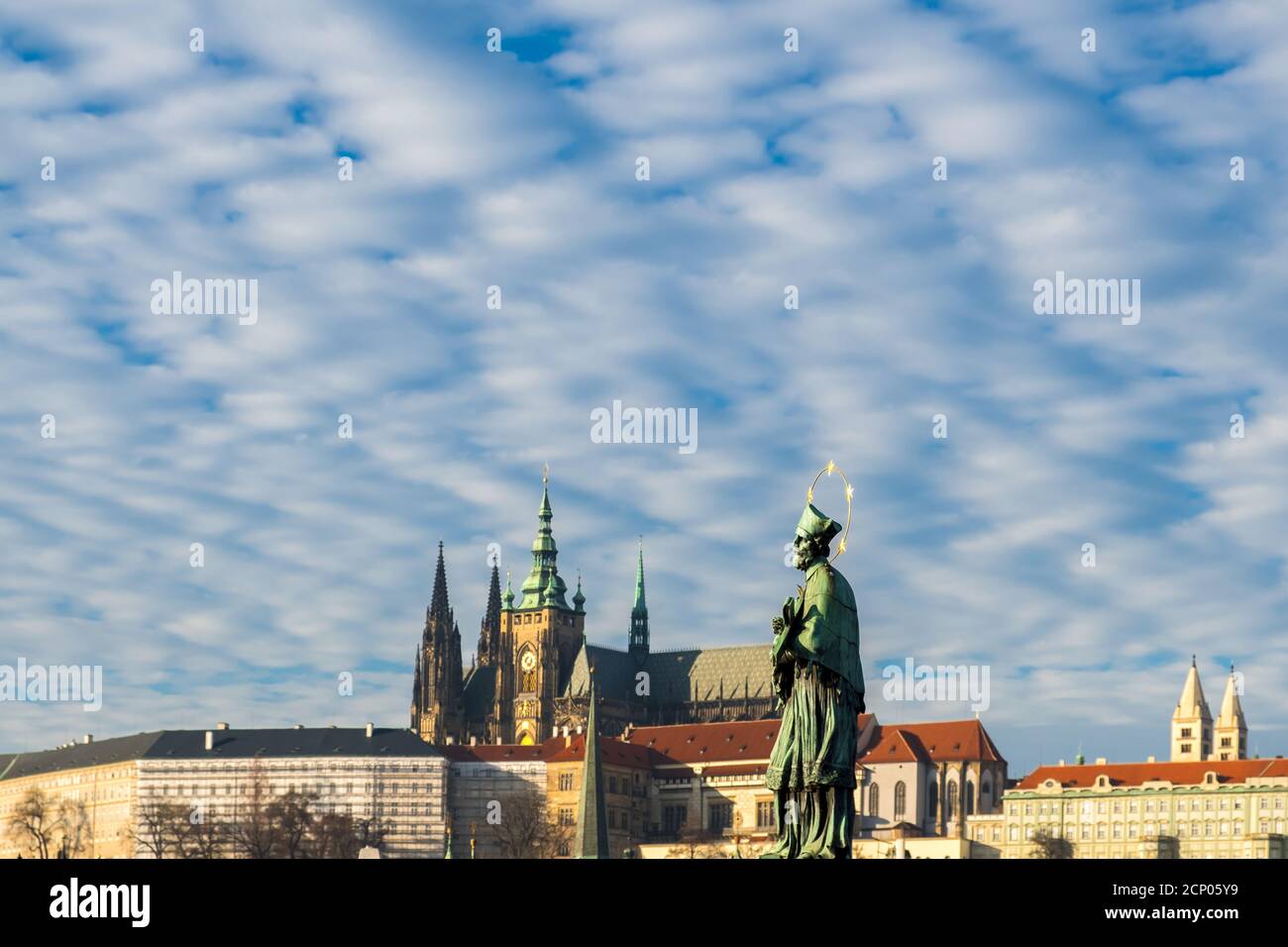 Sculpture of Jan Nepomutsky against a blue sky on Charles Bridge in winter Prague Stock Photo