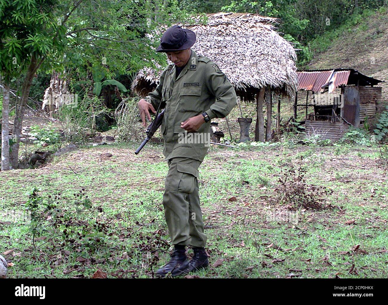 A prison guard watches over a beachside camp for detainees on Panama's penal colony Coiba Island, Panama May 9, 2002. Inspired by French Guiana's notoriously brutal Devil's Island, Coiba became a death camp for political prisoners under the 1980s dictator Manual Noriega. The penal colony, founded in 1919, is due to be shut down over the next two years and plans are underway to tap the island's new status as a national park. REUTERS/Alberto Lowe. TO MATCH FEATURE PANAMA-PRISON-WILDLIFE  AL/SV Stock Photo