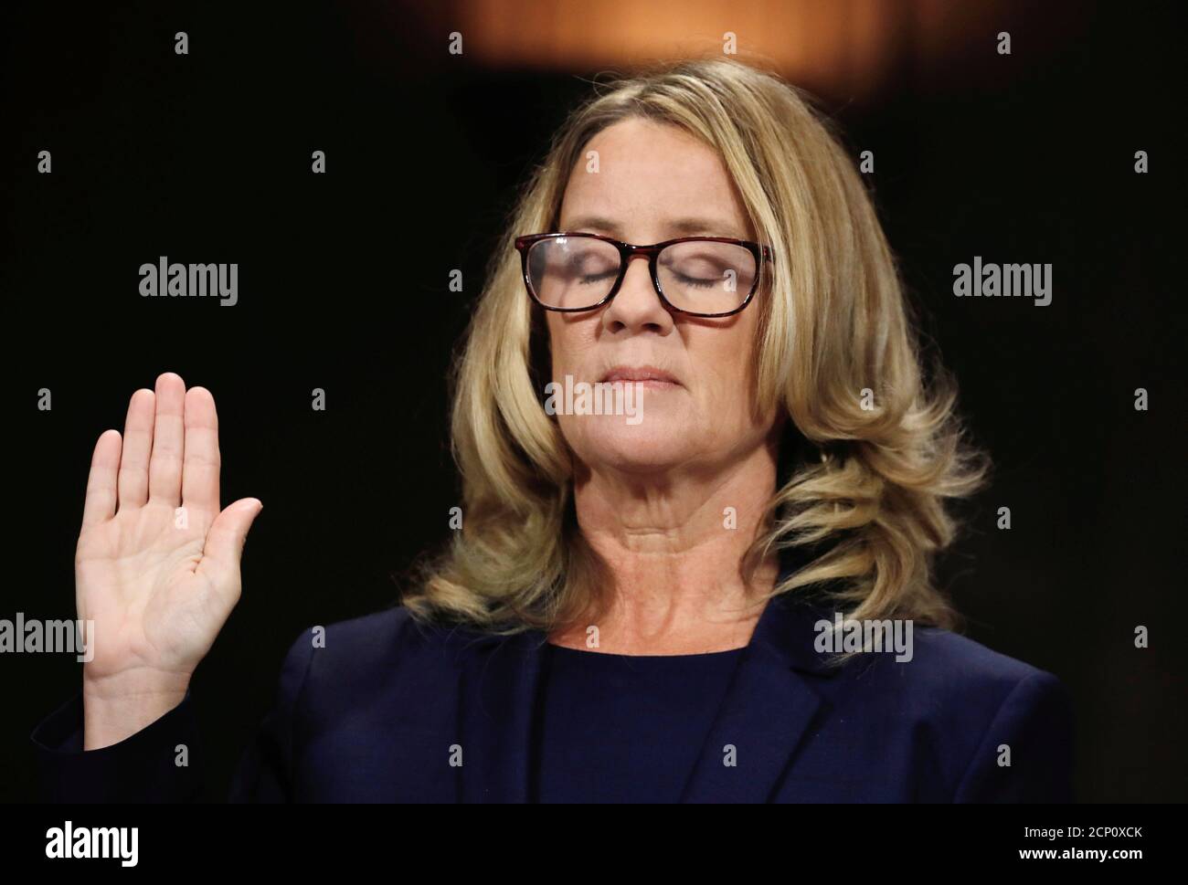 Christine Blasey Ford closes her eyes as she is sworn in before testifying to the Senate Judiciary Committee confirmation hearing for President Donald Trump's Supreme Court nominee Judge Brett Kavanaugh on Capitol Hill in Washington, U.S., September 27, 2018. Reuters photographer Jim Bourg: 'The moment looks peaceful as if Christine Blasey Ford had closed her eyes in thought, but the image actually reflects the fact that in the nine seconds that she had her hand up to be sworn in to testify, she blinked several times. Blasey Ford began her testimony by saying: 'I am here today not because I wa Stock Photo
