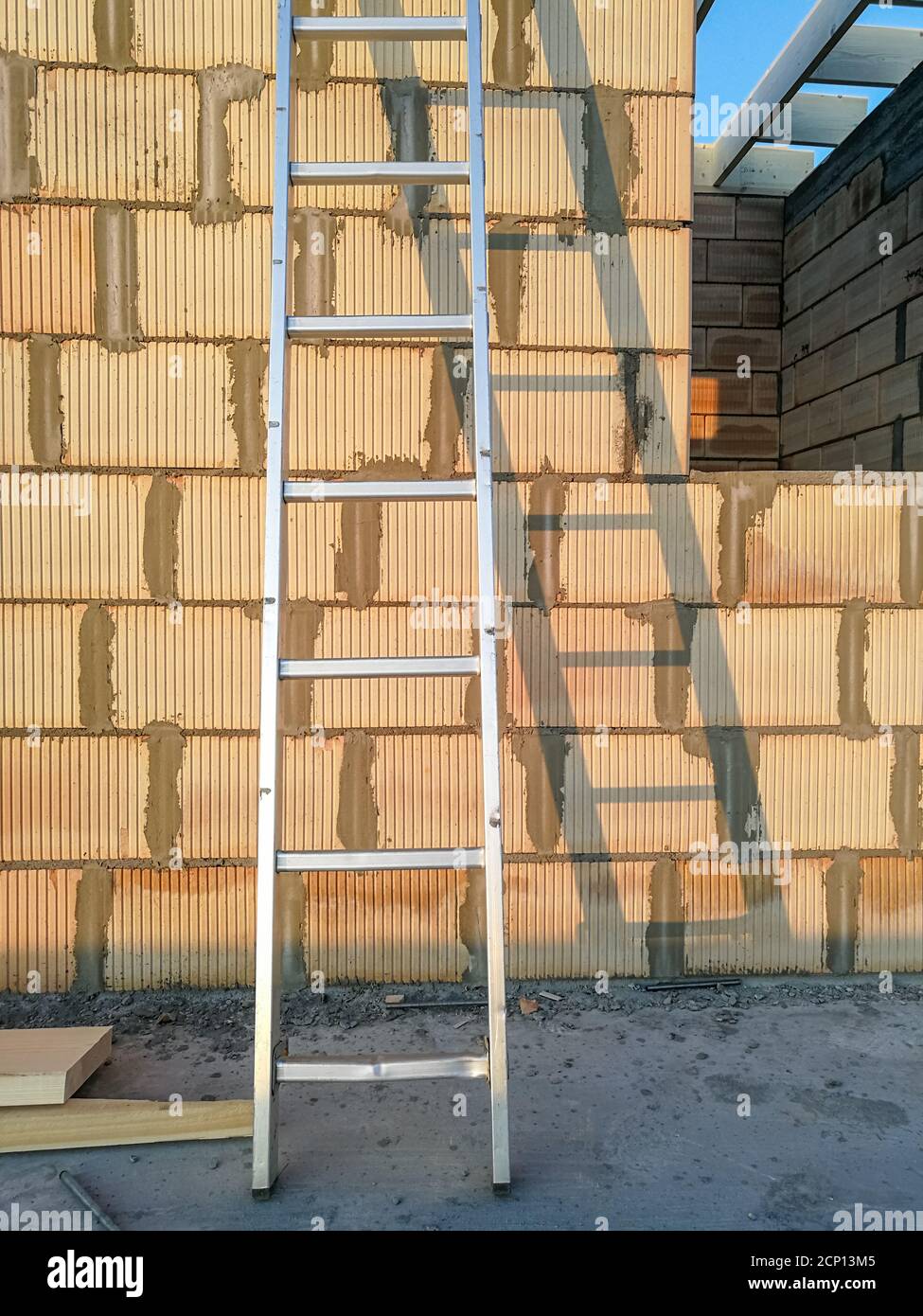 Aluminium ladders close to ceramic brick wall outdoor in construction