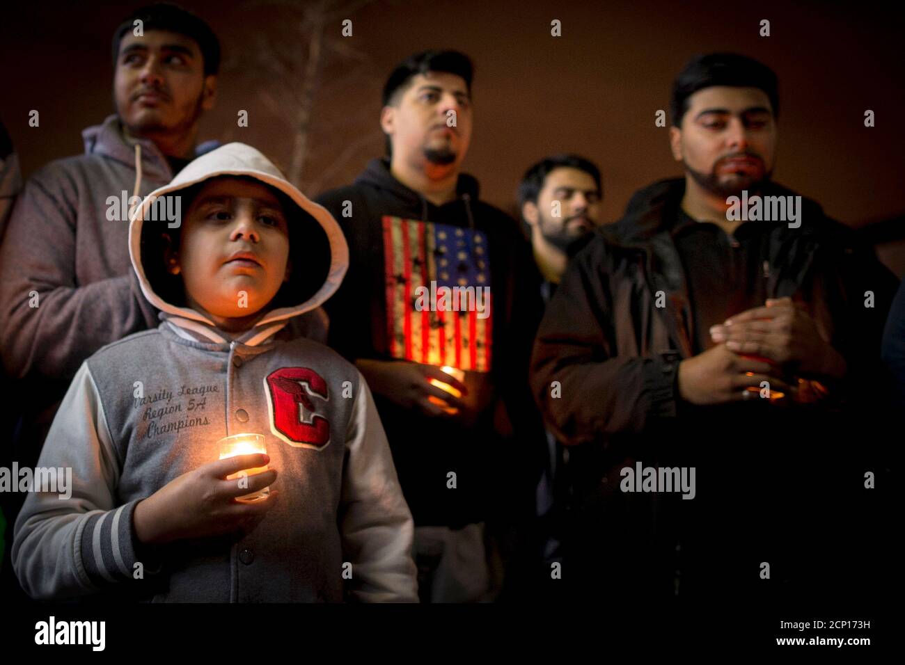 People hold candles during a vigil for victims killed in the attack by Taliban gunmen on the Army Public School in Peshawar Pakistan, in the Brooklyn borough of New York December 17, 2014. Pakistan on Wednesday began burying 132 students killed in a grisly attack on their school by Taliban militants that has heaped pressure on the government to do more to tackle an increasingly aggressive Taliban insurgency. REUTERS/Brendan McDermid (UNITED STATES - Tags: EDUCATION CRIME LAW SOCIETY CIVIL UNREST) Stock Photo