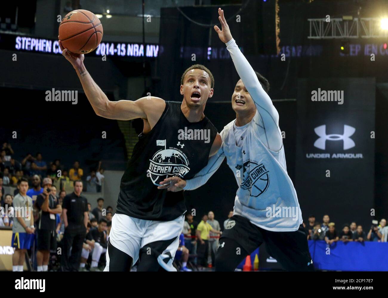 NBA Golden State Warriors' Most Valuable Player (MVP) Stephen Curry is  guarded by a local player during an exhibition game at an arena in Manila  September 5, 2015. Curry arrived in Manila