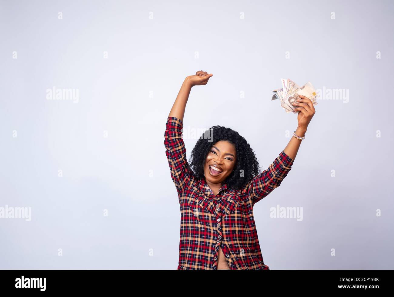 pretty young african lady holding a wad of cash celebrating Stock Photo