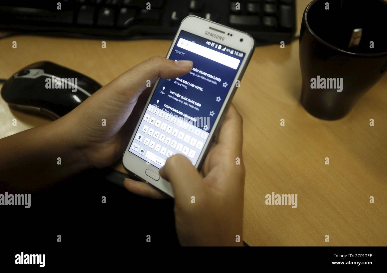 A woman uses her smartphone to book for a taxi in Hanoi, Vietnam 