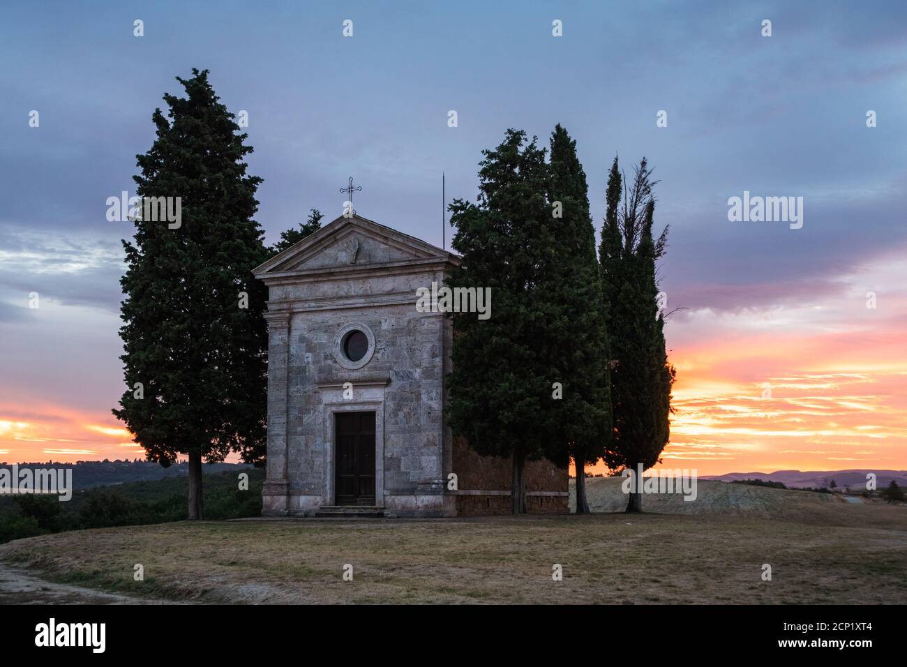 Chapel Cappella della Madonna di Vitaleta in Val d' Orcia, Tuscany, Italy at Sunrise or Dawn in the Romantic and Mysterious First Light Stock Photo