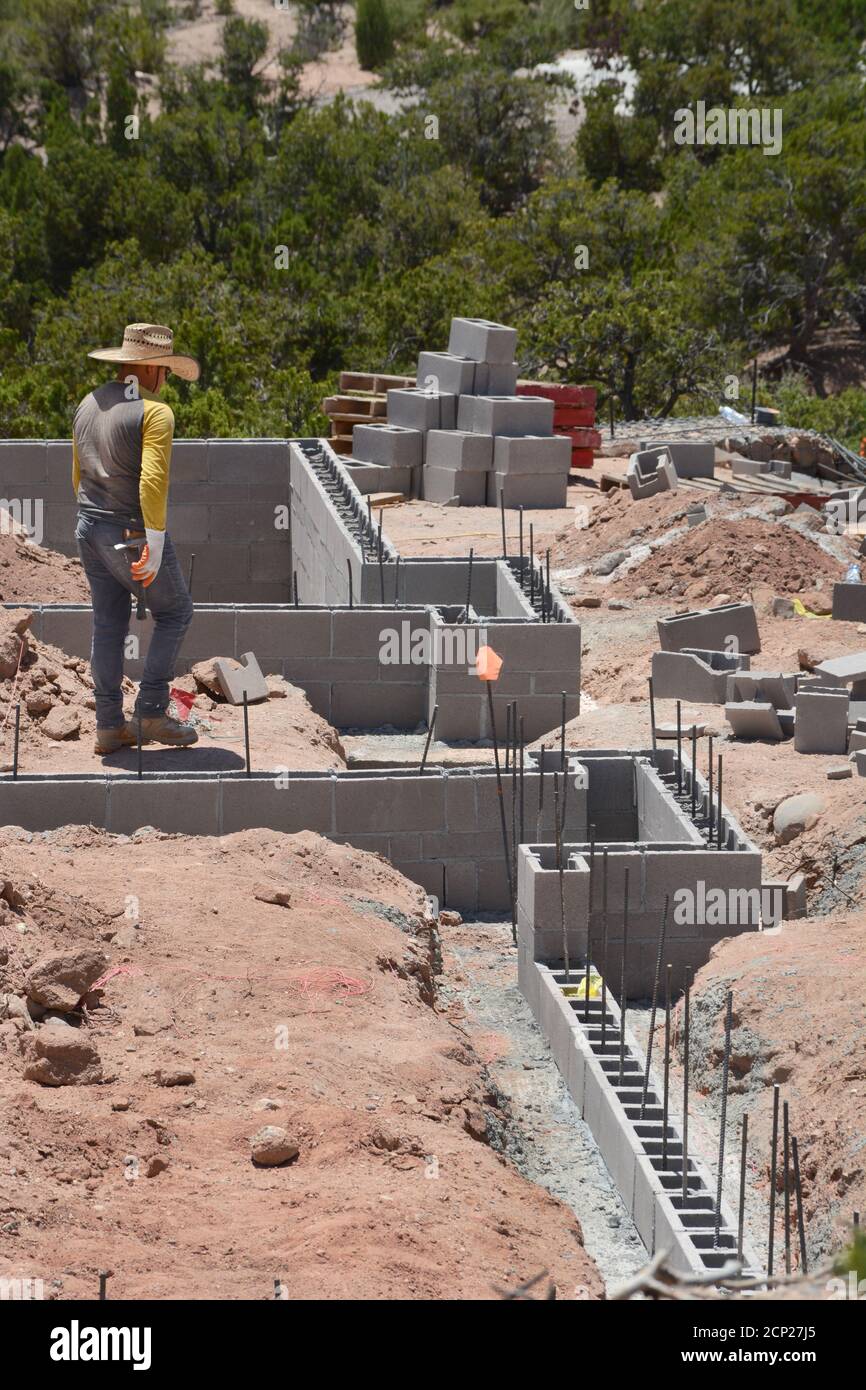 Construction laborers work on the cinderblock foundation of a new home under construction in Santa Fe, New Mexico USA. Stock Photo