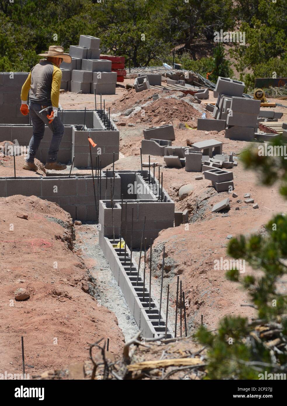 Construction laborers work on the cinderblock foundation of a new home under construction in Santa Fe, New Mexico USA. Stock Photo