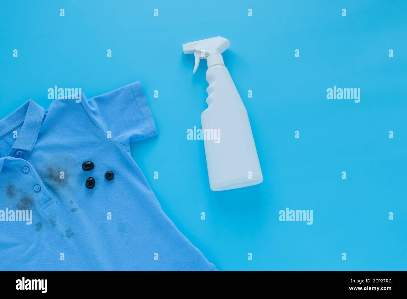 dirty black olive stains on clothes and stain removers. Stain cleaners.top view. Isolated on a blue background Stock Photo