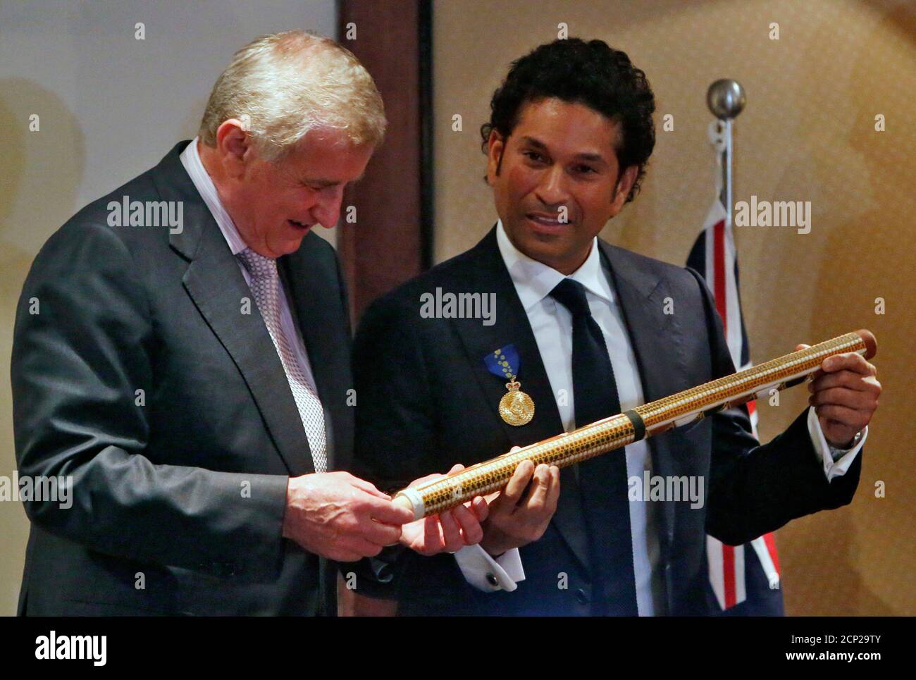 Indian cricket player Sachin Tendulkar (R) and Australia's Minister for the Arts and Regional Australia Simon Crean hold a cricket stump painted by an Australian aboriginal artist during a ceremony at a hotel in Mumbai, November 6, 2012. Tendulkar was conferred the Order of Australia medal at the ceremony for his achievements and contribution to international cricket and for promoting bilateral ties between Australia and India. REUTERS/Vivek Prakash (INDIA - Tags: SPORT CRICKET) Stock Photo