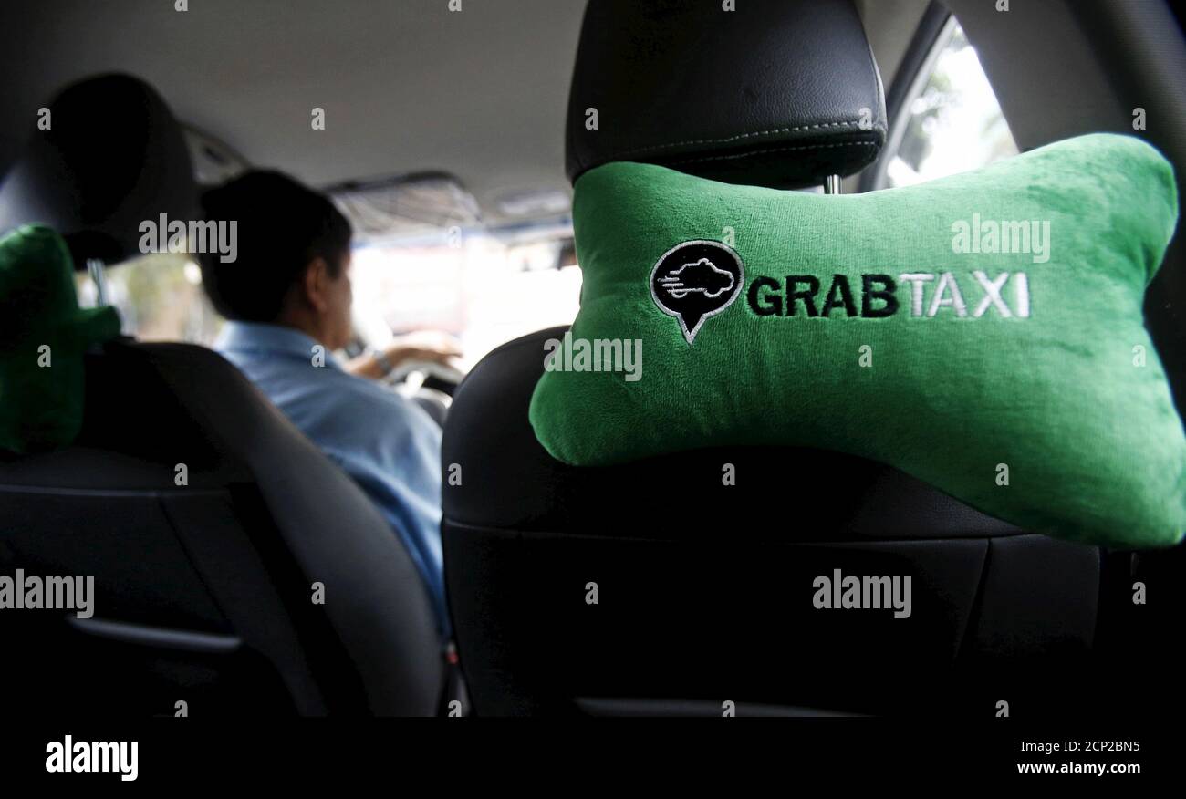 The old GrabTaxi logo is seen on a car neck pillow in a taxi in 