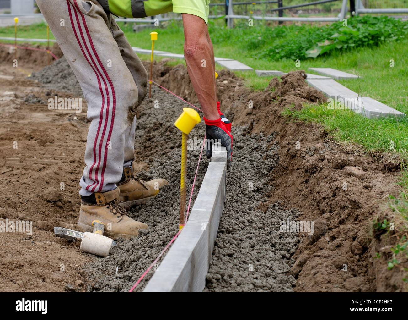 Concrete curb installation. String line level guide is stretched parallel  to the line of course Stock Photo