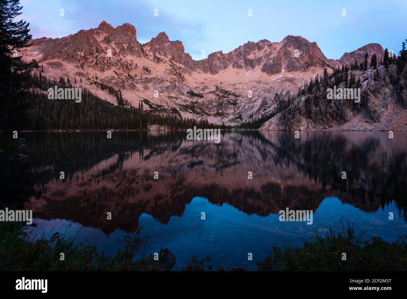 Cramer Lake reflects evening light on the surrounding peak, Sawtooth Wilderness, Idaho, USA. Stock Photo