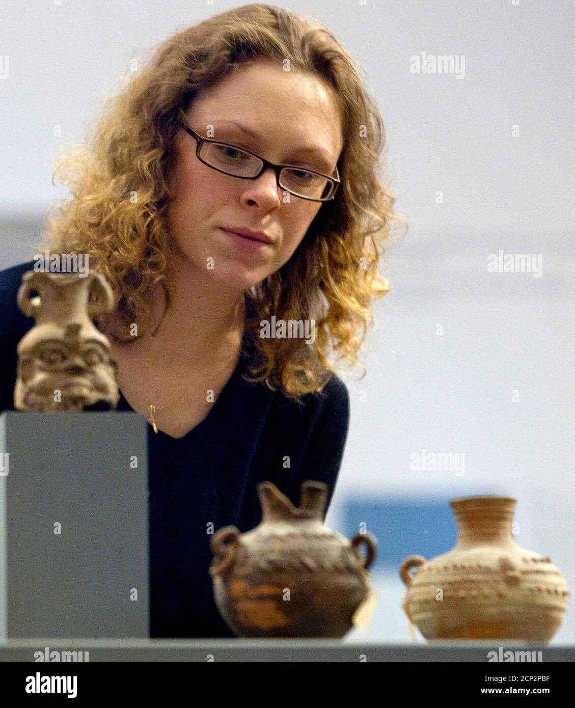 A woman looks at objects of the late antique-byzantine period during their presentation at the Bode Museum in Berlin, February 6, 2012.  The Bode Museum on Monday displayed 40 late antique-byzantine household objects, belonging to its pre-World War Two inventory, after they were returned from the Egyptian Museum of the University of Leipzig where they had been stored since the Soviet Union restituted the items to former East Germany in 1958.    REUTERS/Thomas Peter (GERMANY - Tags: ENTERTAINMENT) Stock Photo