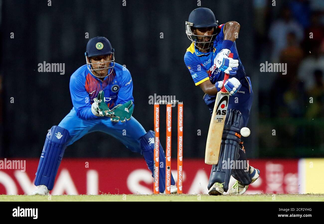 Cricket - Only T20 Match - Sri Lanka v India - Colombo, Sri Lanka - September 6, 2017 - Sri Lanka's Ashan Priyanjan plays a shot next to India's wicket-keeper MS Dhoni. REUTERS/Dinuka Liyanawatte Stock Photo