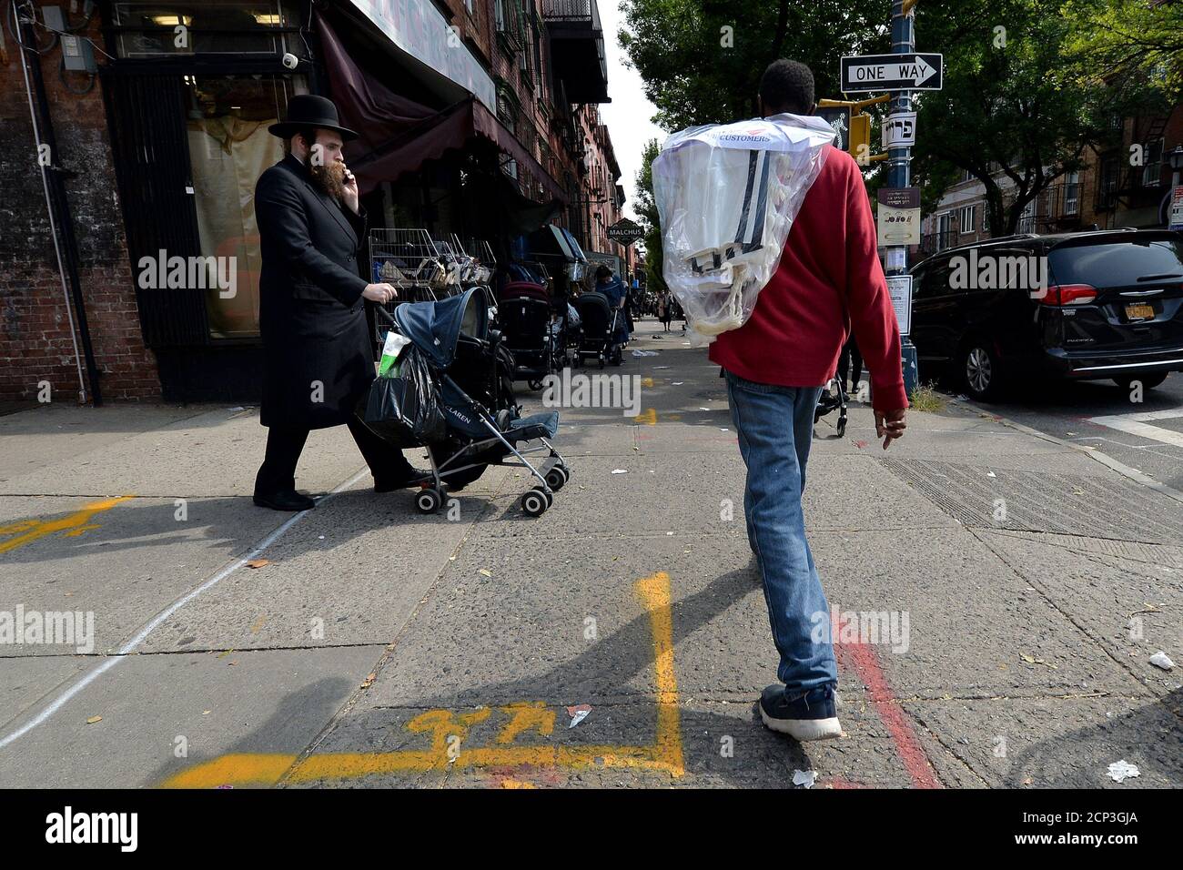 New York City, USA. 18th Sep, 2020. A man from a laundromat walks along Lee Ave. while holding a ‘Tallit” (jewish prayer shawl) for delivery, before the start of the jewish New Year “Rosh Hashanah. in the Williamsburg section of the Brooklyn borough of New York City, NY, September 18, 2020. Rosh Hashanah marks the first of the Jewish High Holy Days, is observed with celebrations, praying in synagogue, the sounding of the Shofar (ram's horn), and eating symbolic foods such as apples dipped in honey to evoke a sweet New Year. (Anthony Behar/Sipa USA) Credit: Sipa USA/Alamy Live News Stock Photo