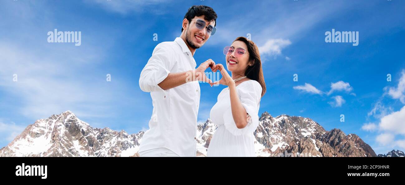 Happy couple of man and woman making heart sign gesture with each of their hand together. Stock Photo