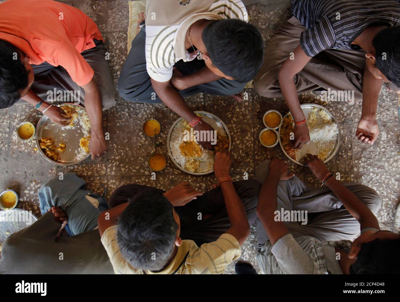 Unmarried men eat their lunch in the remote village of Siyani, where they also live and work in, about 140km (86 miles) west of Gujarat's capital Ahmedabad, October 5, 2011. Siyani is typical of many Indian villages and may be an indicator of things to come as India's male to female ratio declines. The village has some 350 unmarried men over the age of 35 - and hundreds more under 35 - because there aren't enough women to marry. Many women have also left to look elsewhere for grooms with more money and better prospects. Census data released earlier this year revealed there are 914 girls for ev Stock Photo