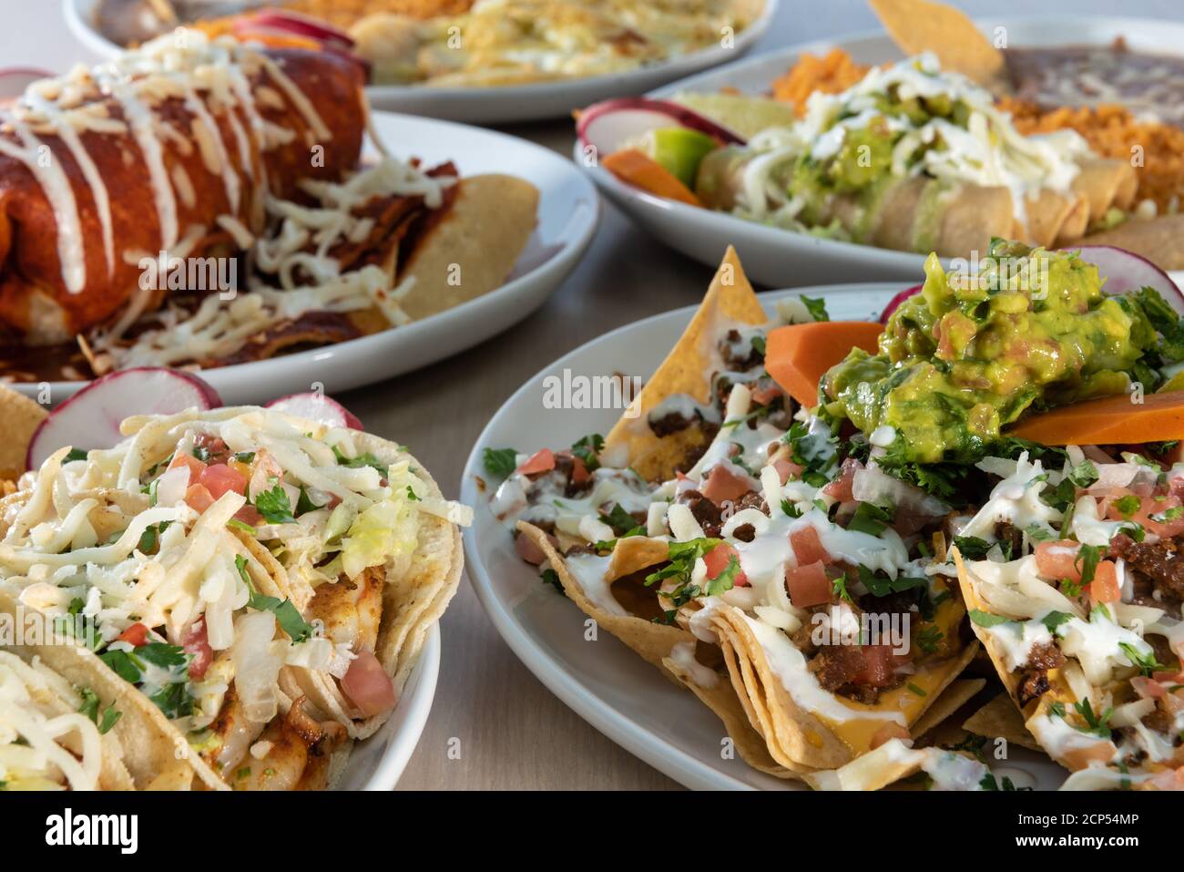Huge selection of delicious Mexican food plates on a table buffet style for the family eating. Stock Photo
