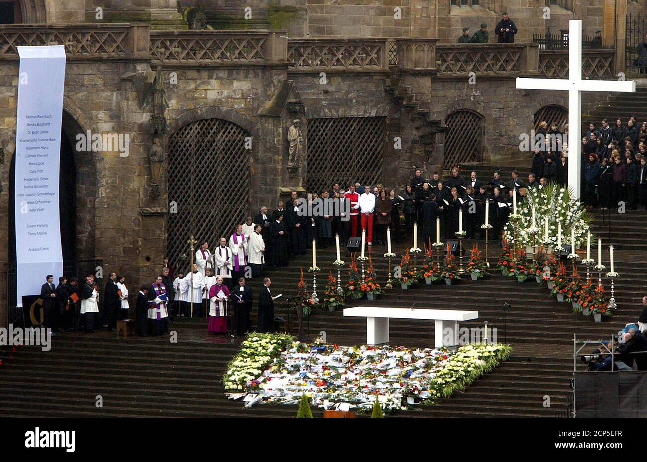 Sixteen candles, flowers and a white cross are placed on the steps of Erfurt cathedral during an official memorial May 3, 2002 for the 16 victims of a shooting at the Gutenberg secondary school one week ago. Robert Steinhaeuser, an expelled 19-year-old student shot and killed 16 people at his former school before turning a gun on himself on April 26. Tens of thousands of people attend the memorial service. REUTERS/Kai Pfaffenbach  KP/WS Stock Photo