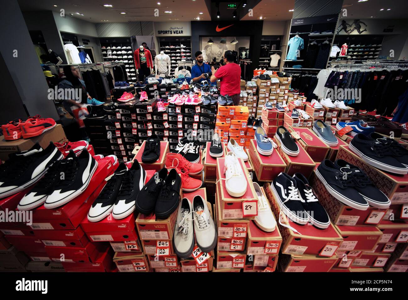 Vans, Puma, Adidas and other shoes brands are seen on sale as store keeper  deals with a customer at Sun & Sand sports store at Bahrain City Center in  Manama, Bahrain September