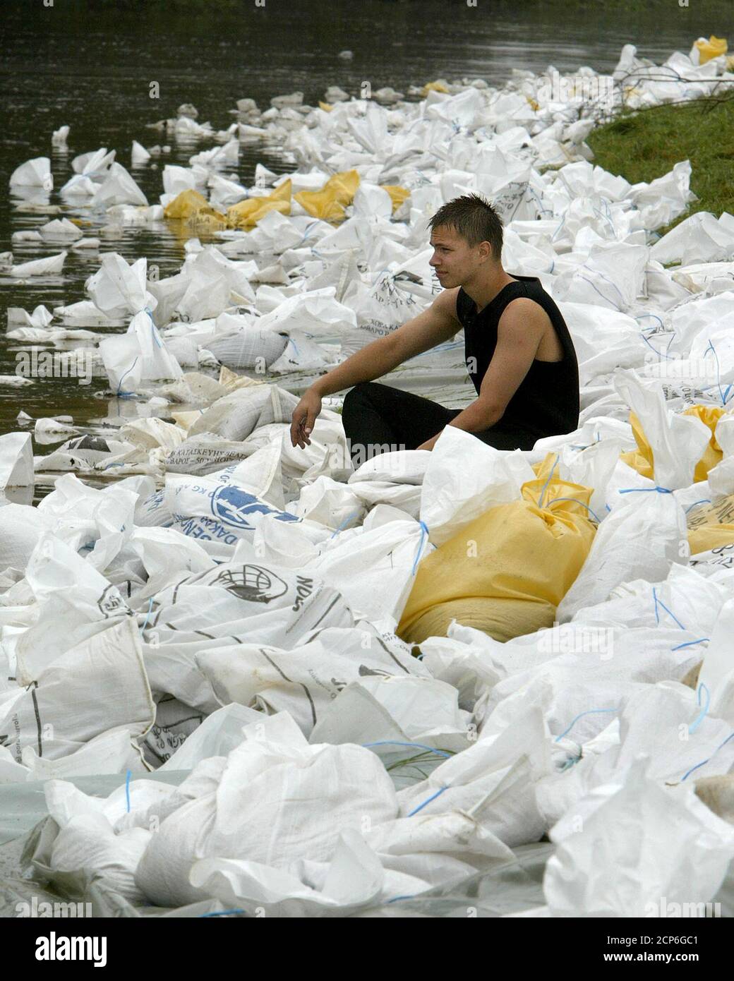 A frogman rests between sand bags reinforcing the dyke on the Jeetzel river in Pisselberg near Dannenberg against flooding from the Elbe river August 25, 2002. The worst floods on record have killed 20 and driven tens of thousands from their homes across eastern Germany, causing a state of emergency to be declared across the region. REUTERS/Christian Charisius REUTERS  CHA/JOH Stock Photo