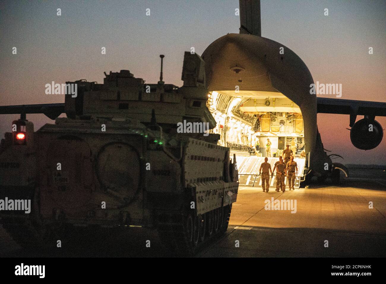 U.S. Army Soldiers and Airmen unload Bradley fighting vehicles from a C-17 aircraft near northeastern Syria Sept.18, 2020. The vehicles will be operated by 1st Battalion, 6th Infantry Regiment, 1st Armored Division Soldiers during operations in support of Combined Joint Task Force Operation Inherent Resolve (CJTF-OIR). CJTF-OIR remains committed to working by, with and through our partners to ensure the enduring defeat of Daesh. (U.S. Army photo by Spc. Jensen Guillory) Stock Photo