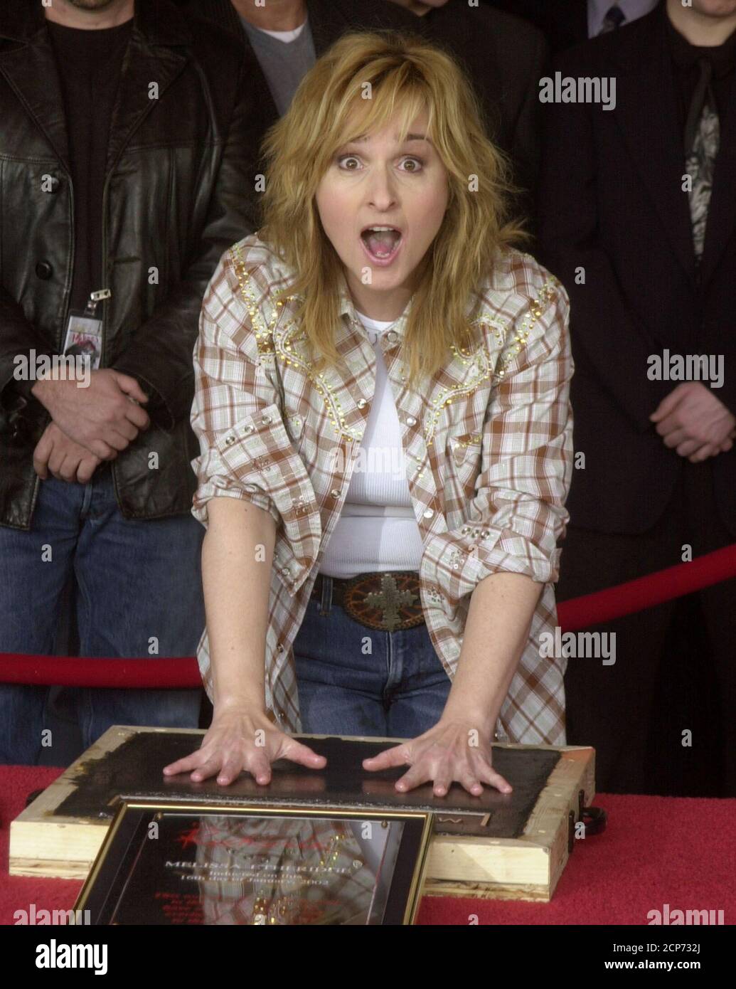 Rock singer and songwriter Melissa Etheridge reacts to the temperature saying, 'ooh, it's cold,'as she places her hands in wet cement during an induction ceremony at Hollywood's Rock Walk January 16, 2002 in Los Angeles, California. Etheridge's handprints and signature will be placed alongside those of other rock luminaries including Jimmy Hendrix, Carl Perkins, Aerosmith and Carlos Santana. REUTERS/Jim Ruymen  JR Stock Photo