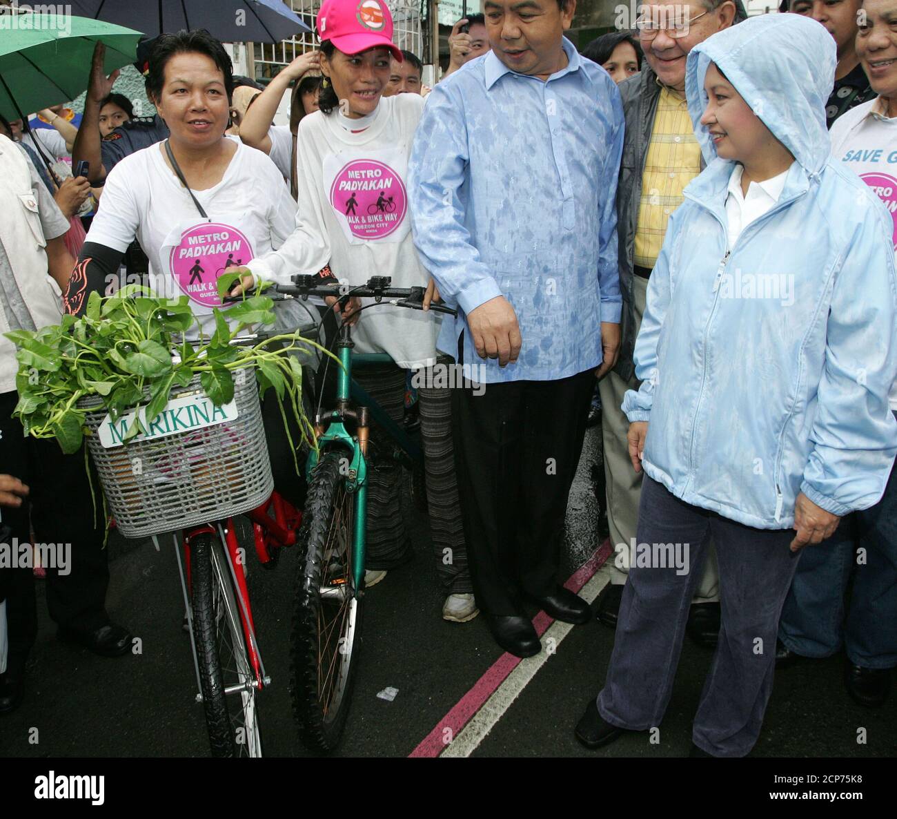 Philippine President Gloria Macapagal Arroyo (R) talk to bikers at the  launch of a Bike Lane and Walkway pilot project in Quezon city, suburban  Manila September 24, 2005. The government is encouraging