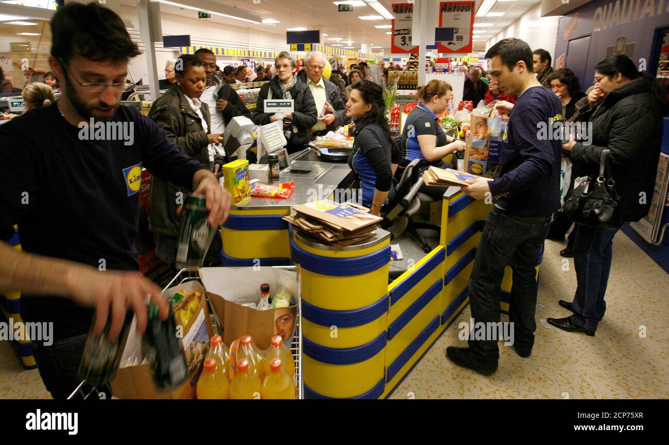 An employee packs the bag for a customer at the cash desk of a new Lidl