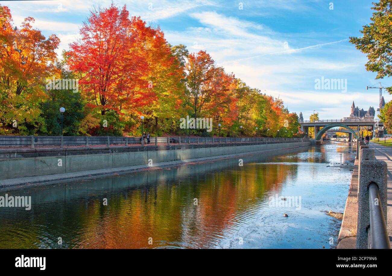 Beautiful autumn foliage and reflections along Rideau Canal and pathway in Ottawa, Ontario, Canada Stock Photo