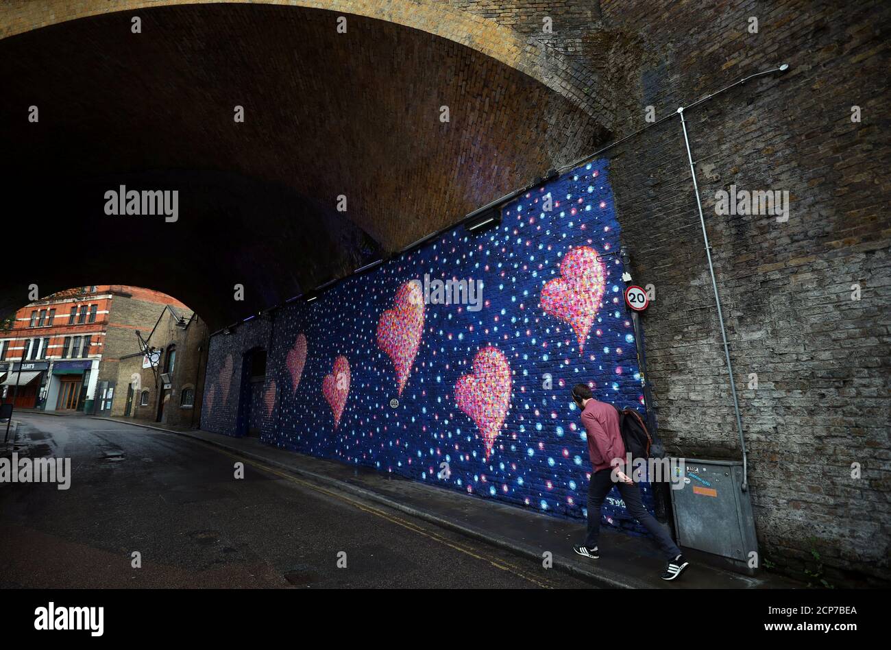 A man walks past a mural, by British-born Australian artist James Cochran, painted to commemorate the victims of the London Bridge attack, in London, Britain, April 2, 2018. REUTERS/Hannah McKay Stock Photo