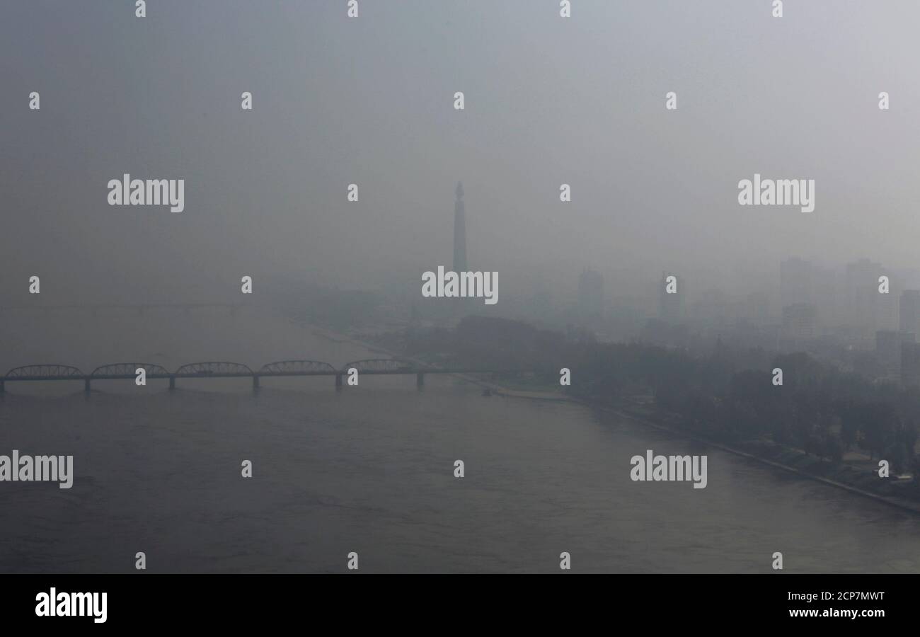 The 170-metre (558-ft) tall Juche Tower (C) stands beside the Taedong River, amid morning fog in Pyongyang July 26, 2013. REUTERS/Jason Lee (NORTH KOREA - Tags: POLITICS ENVIRONMENT TPX IMAGES OF THE DAY) Stock Photo