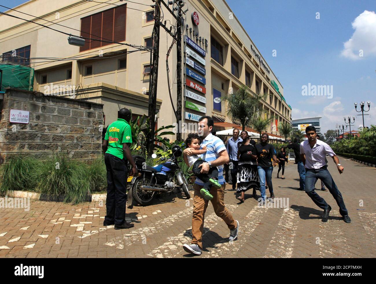 Customers run following a shootout between unidentified armed men and the police at the Westgate shopping mall in Nairobi September 21, 2013. At least nine people were killed in a shooting in the shopping mall in the Kenyan capital, Nairobi, on Saturday, witnesses said. REUTERS/Thomas Mukoya (KENYA - Tags: CIVIL UNREST) Stock Photo