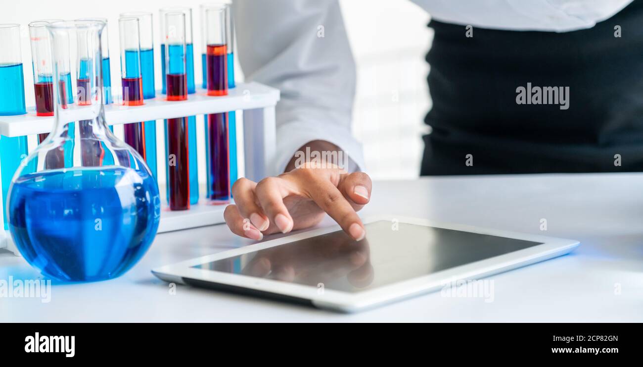 Woman scientist working in laboratory and examining biochemistry sample in test tube. Science technology research and development study concept. Stock Photo