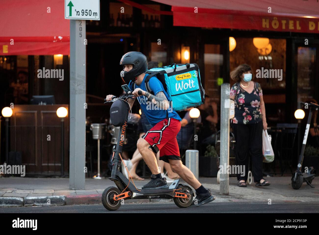 A courier working with Wolt, a meal delivery app service, rides a scooter  as he delivers an order from a restaurant amid the coronavirus disease  (COVID-19) crisis, in Tel Aviv, Israel July