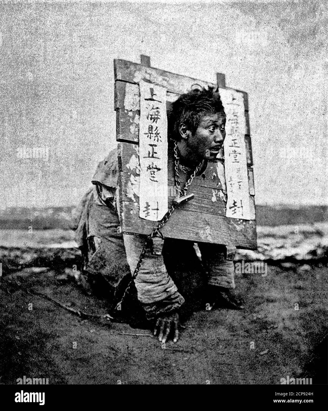 A man in a cangue in Shanghai, circa 1890. A cangue or tcha is a device that was used for public humiliation and corporal punishment in East Asia and some other parts of Southeast Asia until the early years of the twentieth century Stock Photo