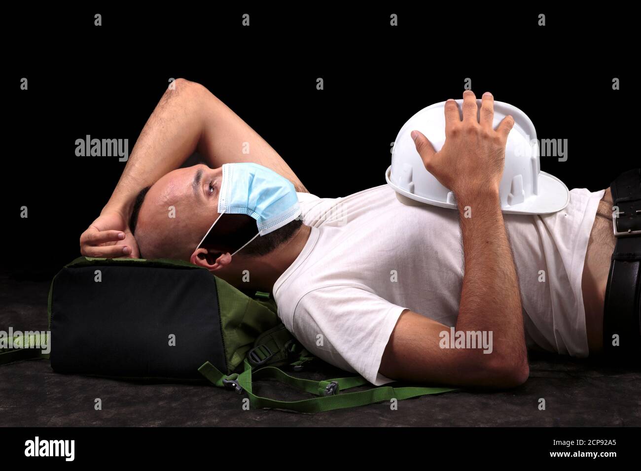 Young hispanic male construction worker with mask taking a siesta Stock Photo