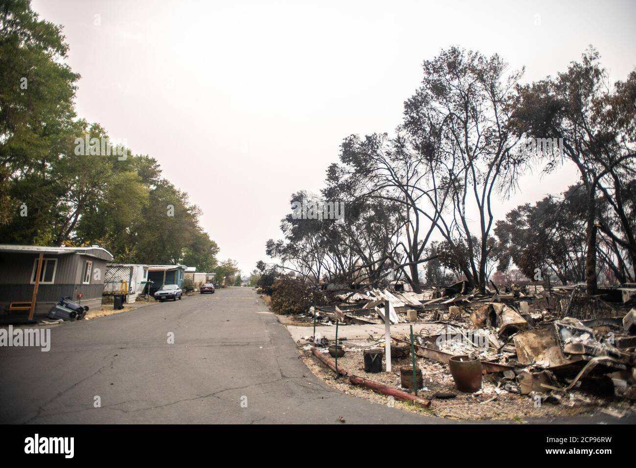 TALENT, ORE - SEPTEMBER 18, 2020: A general view separation between the burned area and the safe area of the Talent Mobile Estates #81 which were sprayed with fire retardent during the Almeda Fire. The town of Talent, Oregon, showing the burned out homes, cars and rubble left behind. In Talent, about 20 miles north of the California border, homes were charred beyond recognition. Across the western US, at least 87 wildfires are burning, according to the National Interagency Fire Center. They've torched more than 4.7 million acres -- more than six times the area of Rhode Island. Credit: Chris Tu Stock Photo