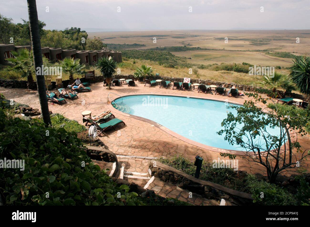 Tourists are seen by the poolside of the Mara Serena Safari Lodge, within the Masai Mara game reserve, southwest of Nairobi, Kenya, July 28, 2009. Picture taken July 28, 2009. REUTERS/Thomas Mukoya     TPX IMAGES OF THE DAY Stock Photo
