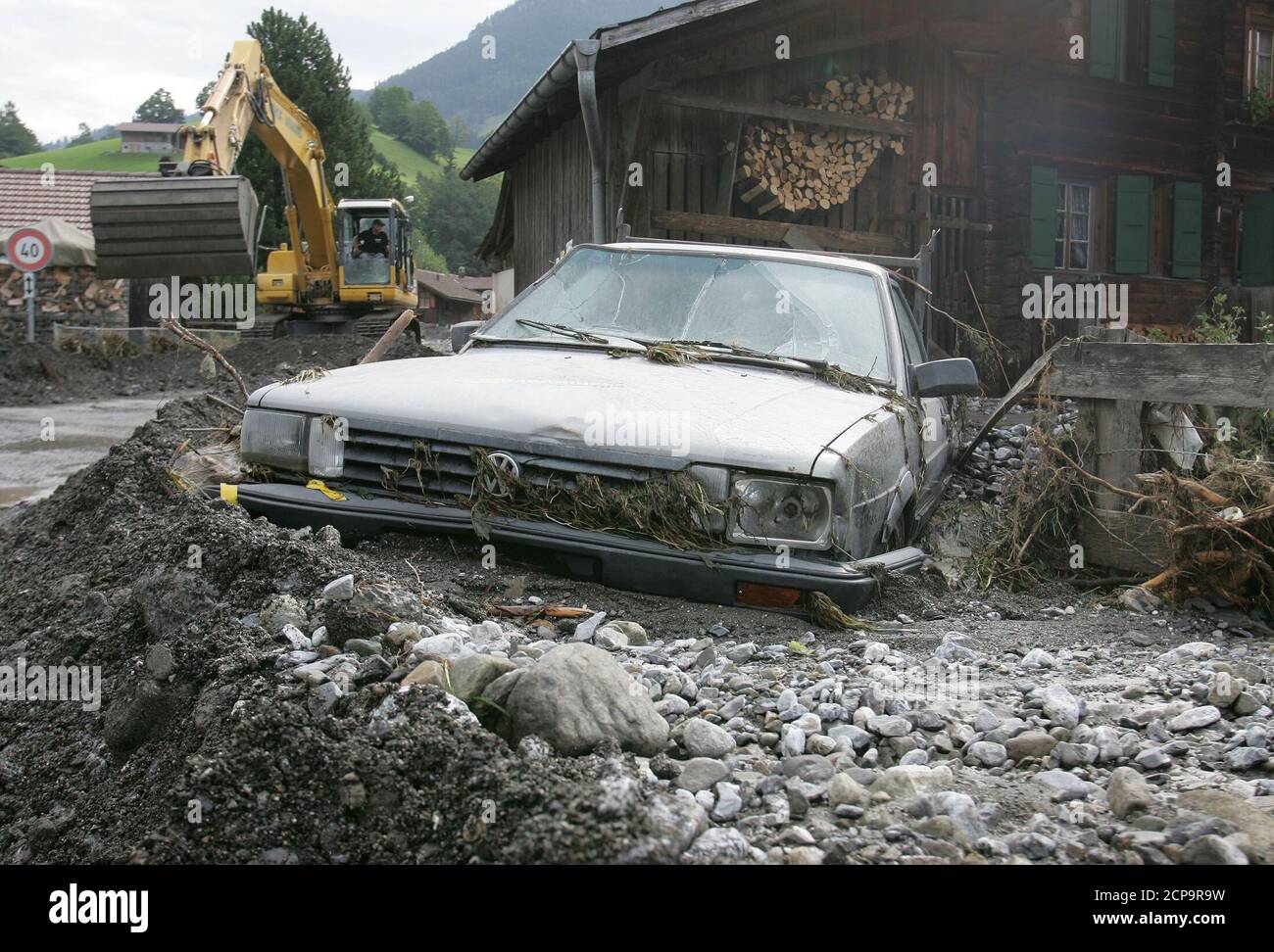 A destroyed car is seen among debris and stones following floods in the  central Swiss town of Kien, Switzerland, August 25, 2005. Emergency  services and residents began a clean up process in