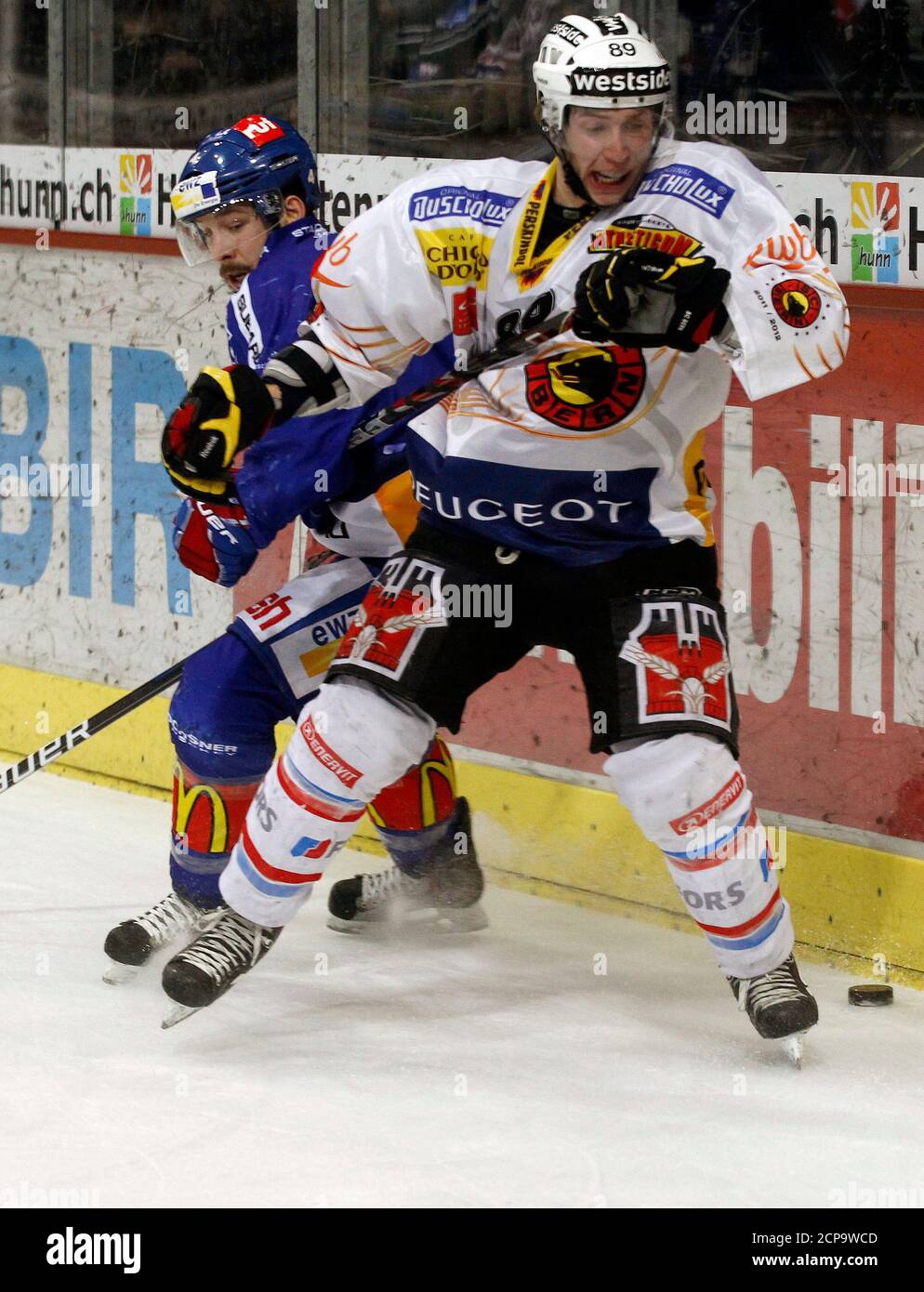 ZSC Lions' Patrick Geering (L) challenges SC Bern's (SCB) Pascal Berger during their Swiss ice hockey play-off final at the Hallenstadion arena in Zurich April 14, 2012. REUTERS/Arnd Wiegmann (SWITZERLAND - Tags: SPORT ICE HOCKEY) Stock Photo