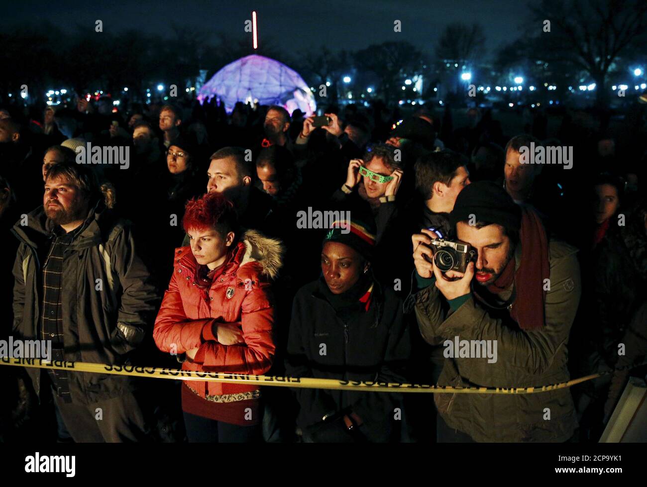 A crowd watches as an interactive art installation created by artist Michael Verdon called the “Temple of Essence” and dedicated to victims of the 'war on drugs' is burned on the U.S. National Mall in Washington November 22, 2015.  People were encouraged to write personal messages on the temple walls and leave mementos behind inside the interactive art piece, which was the centerpiece of a 48-hour vigil called 'Catharsis on the Mall: A Vigil for Healing the Drug War.'     REUTERS/Jim Bourg Stock Photo